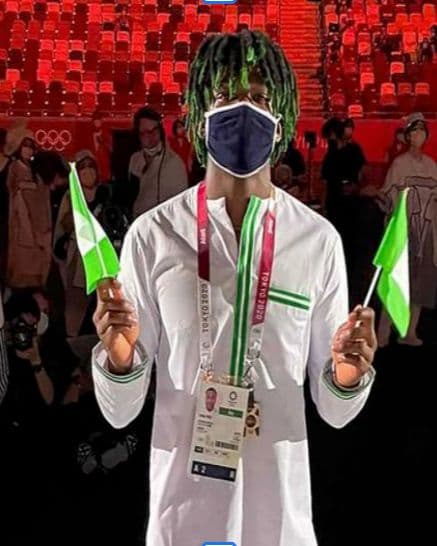 Uche Eke, President of Igbere Youth, holding Nigerian flags